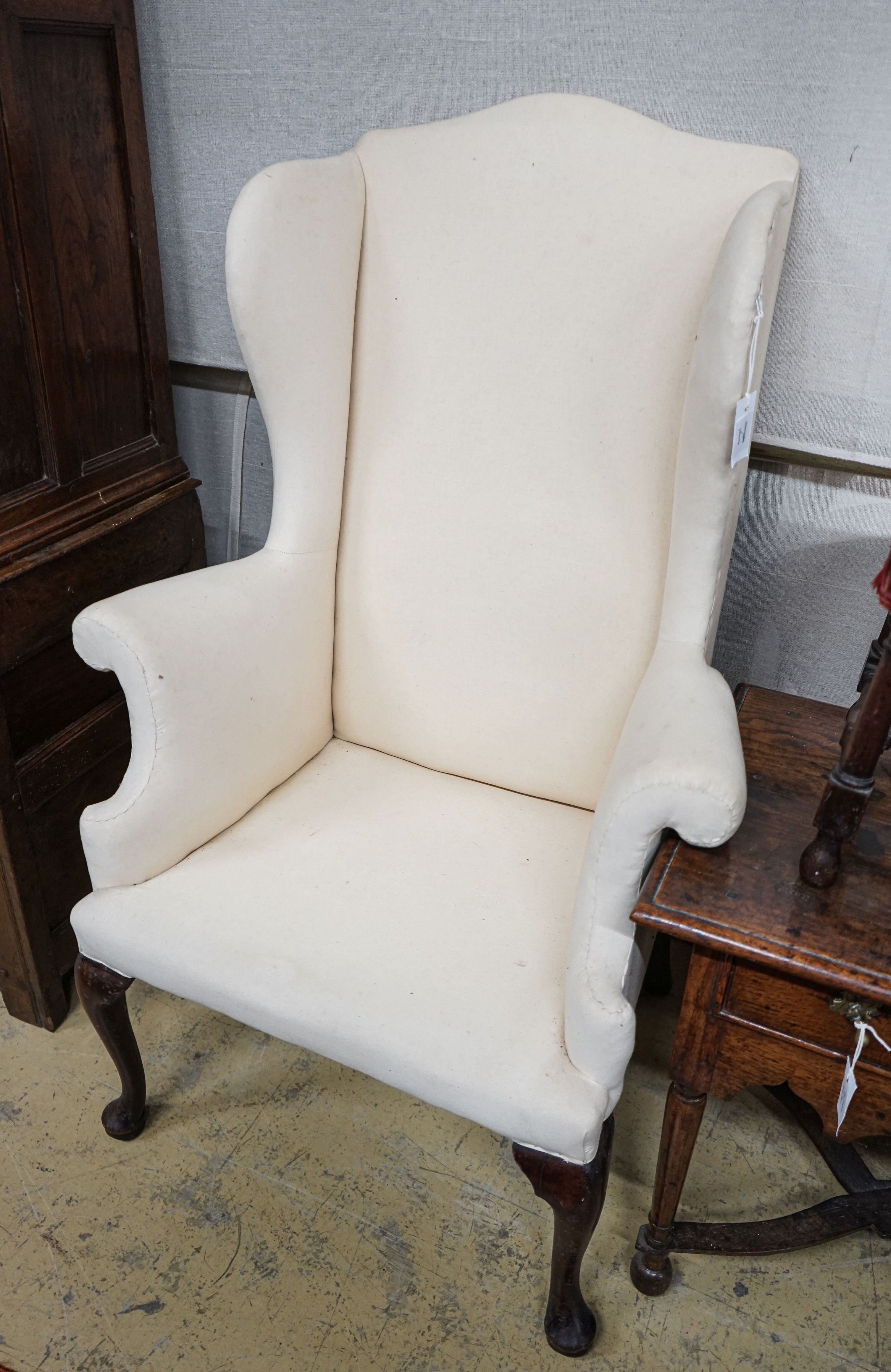A George II mahogany wingback armchair, with slender cabriole legs and pad feet, width 80cm, depth 66cm, height 126cm